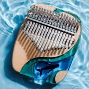 The Hluru Deep Sea Whale 17 key kalimba partially submerged in clear, rippling water.