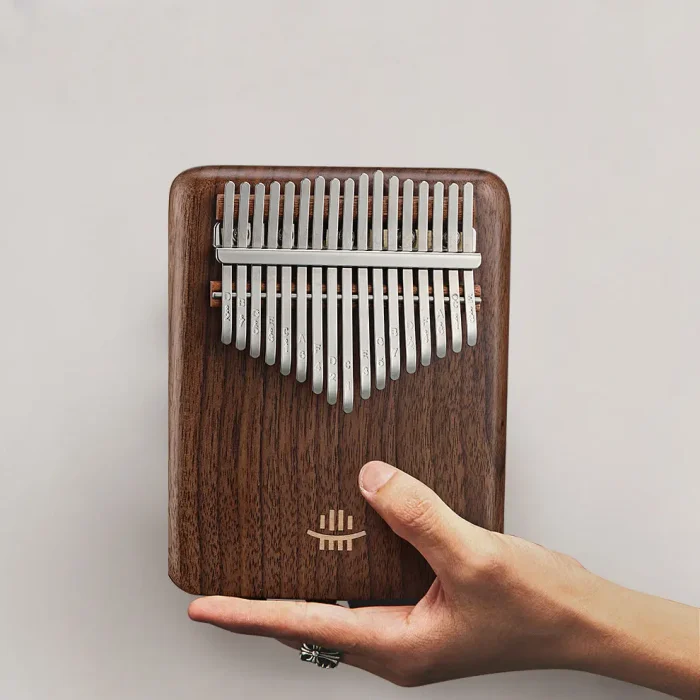 Person holding Hluru 17 key electric kalimba with rosewood body