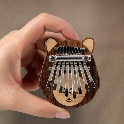 Hand holding the Hluru 8 Key Mini Totoro Kalimba made of Black Walnut wood