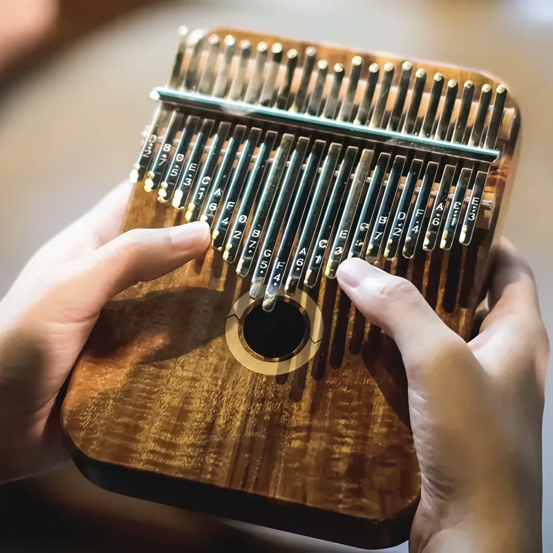 A musician playing a curly-grained Acacia 21 key kalimba, showing proper hand placement.